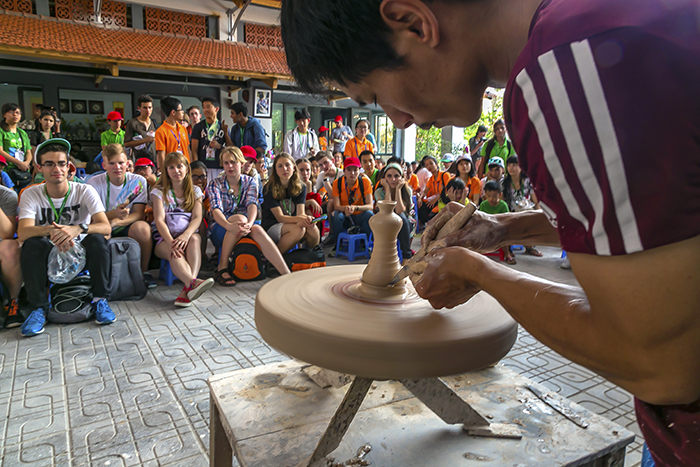 Visitors take a close look at the processing of ceramic product. Photo: Nguyen Huynh Mai